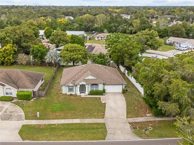 an aerial view of residential houses with outdoor space and trees