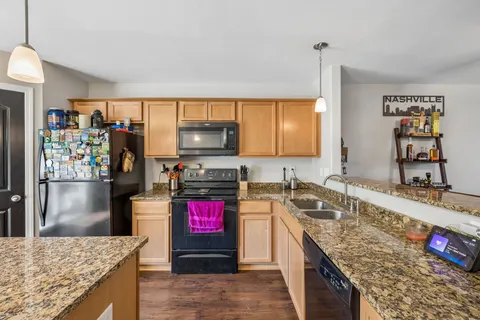 a kitchen with stainless steel appliances granite countertop a sink stove and refrigerator