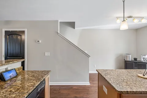 a kitchen with kitchen island granite countertop a sink and a stove