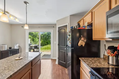 a kitchen with granite countertop a refrigerator a stove and a sink