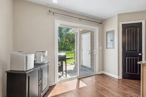 a view of a kitchen with a fridge and wooden floor