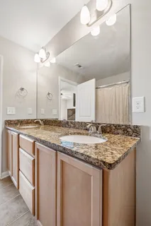 a bathroom with a granite countertop sink and a mirror