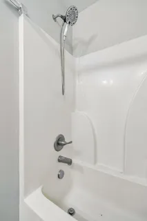 a bathroom with a bath tub with a shower