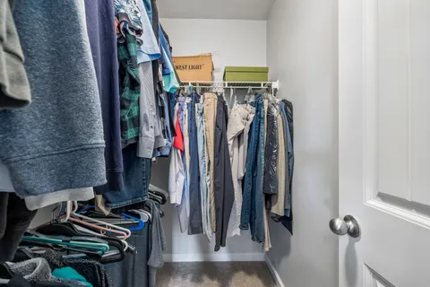 a view of walk in closet with clothes