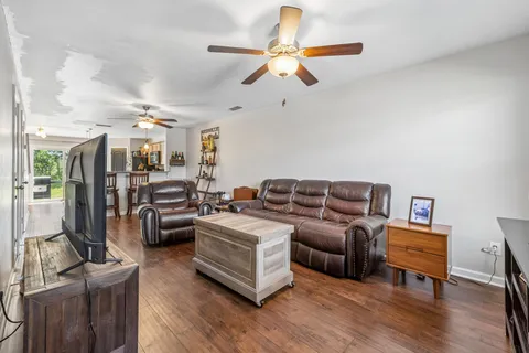 a living room with furniture ceiling fan and a rug