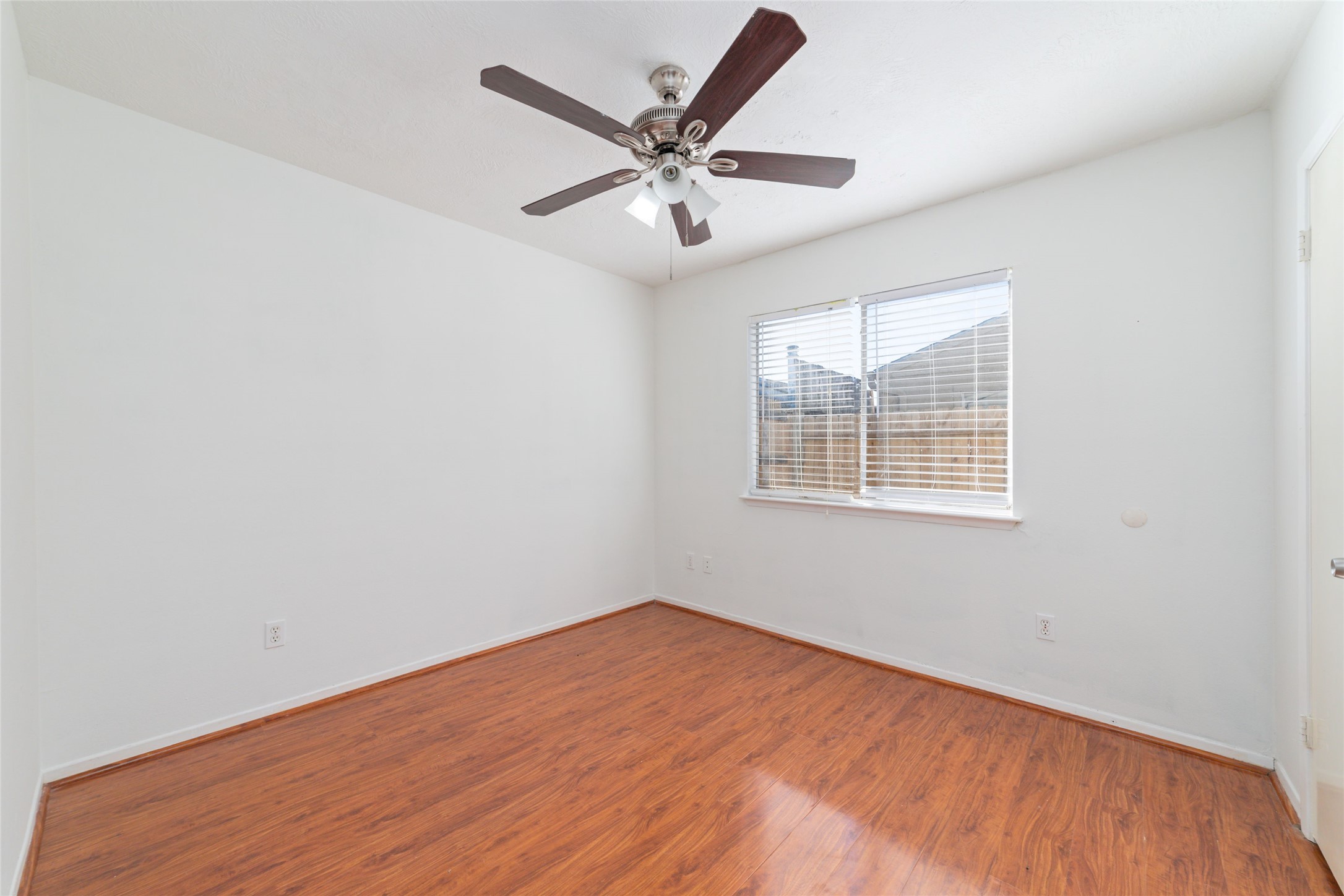 4222 Amir Street Houston, TX 77072 - Photo 9 of 21 an empty room with wooden floor ceiling fan and windows