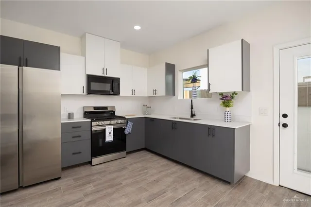 a kitchen with a sink cabinets stainless steel appliances and a window
