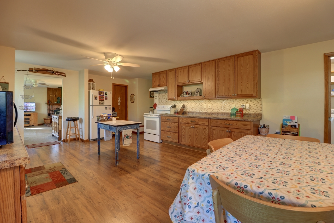 14755 Fenton Road Morrison, IL 61270 - Photo 4 of 34 a living room with stainless steel appliances kitchen island granite countertop a sink a dining table and chairs with wooden floor