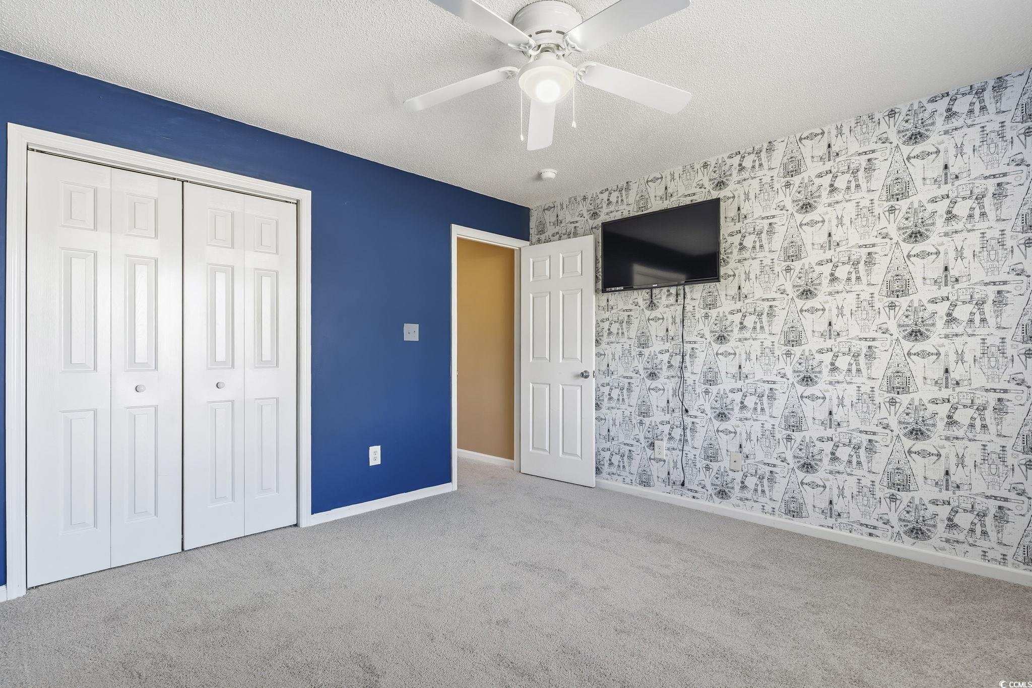 1007 Green Fir Loop Conway, SC 29527 - Photo 18 of 38 Unfurnished bedroom with a textured ceiling, carpet, a closet, ceiling fan, and wallpapered walls