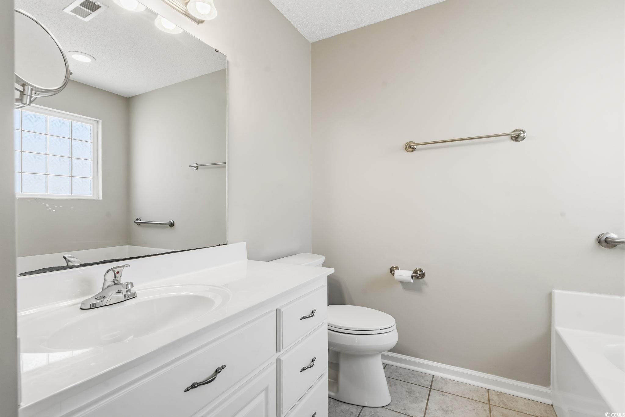 1007 Green Fir Loop Conway, SC 29527 - Photo 29 of 38 Bathroom with light tile patterned flooring, a bath, vanity, and a textured ceiling
