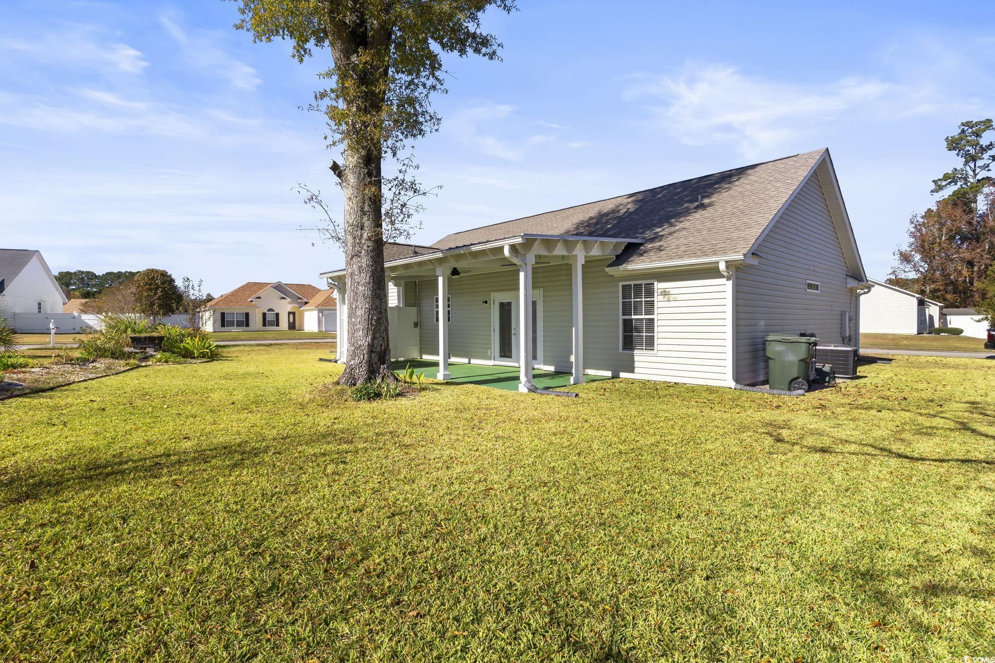 1007 Green Fir Loop Conway, SC 29527 - Photo 37 of 38 Back of property featuring a patio, a shingled roof, and a lawn