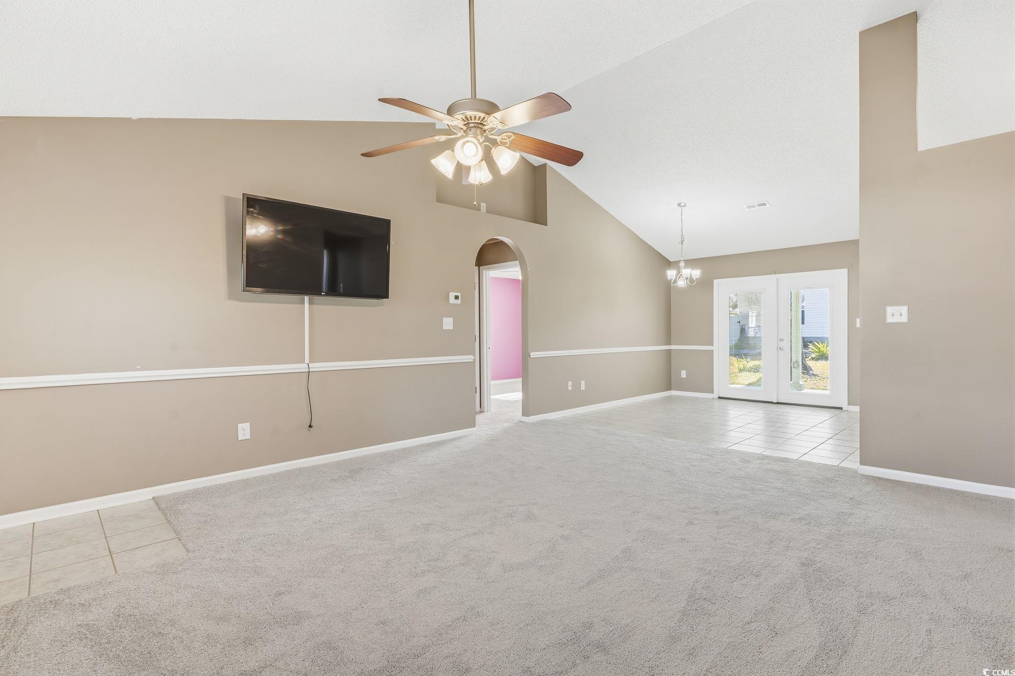 1007 Green Fir Loop Conway, SC 29527 - Photo 5 of 38 Unfurnished living room featuring light tile patterned flooring, light colored carpet, high vaulted ceiling, arched walkways, and ceiling fan