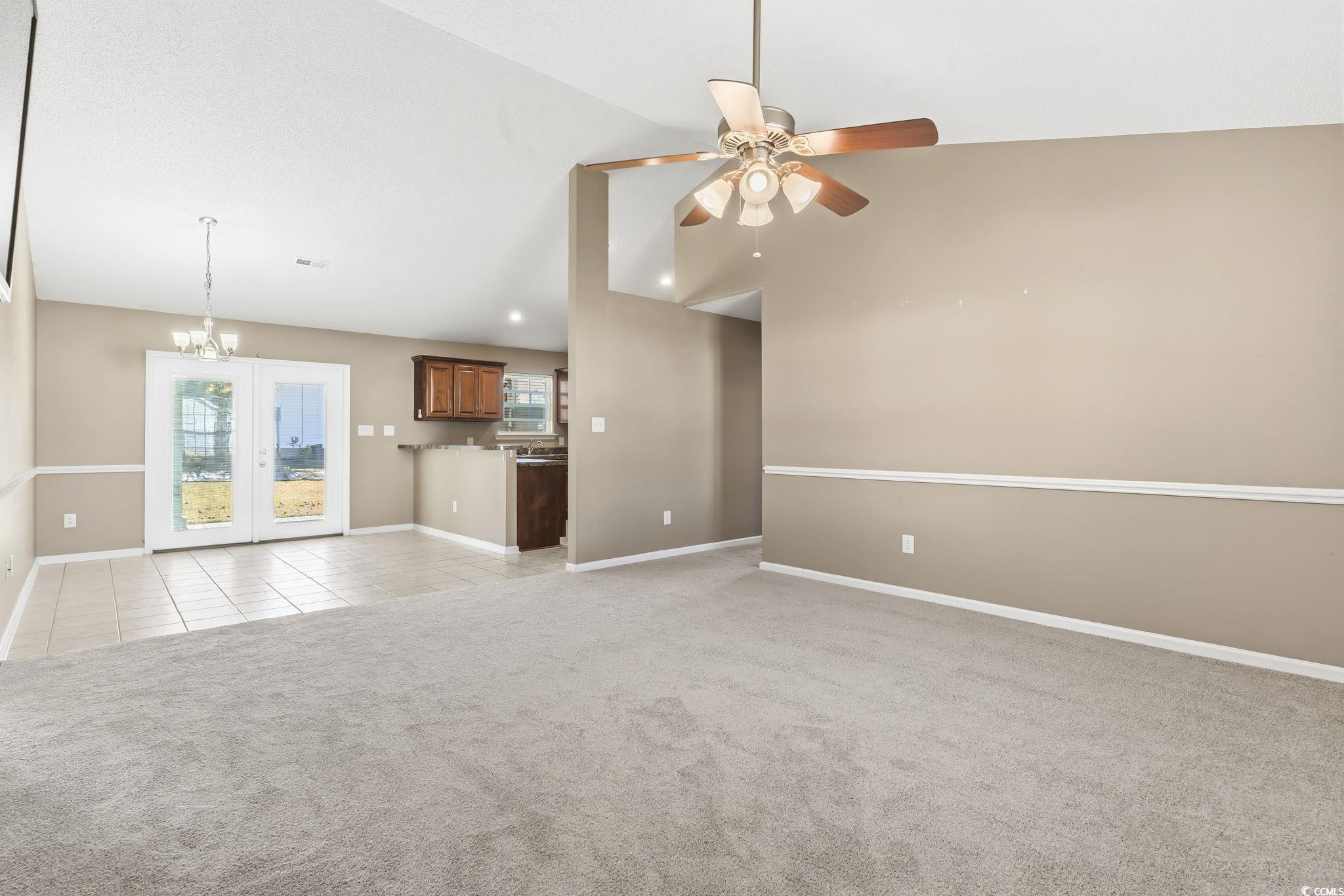 1007 Green Fir Loop Conway, SC 29527 - Photo 6 of 38 Unfurnished living room featuring light tile patterned floors, a chandelier, light carpet, vaulted ceiling, and a ceiling fan