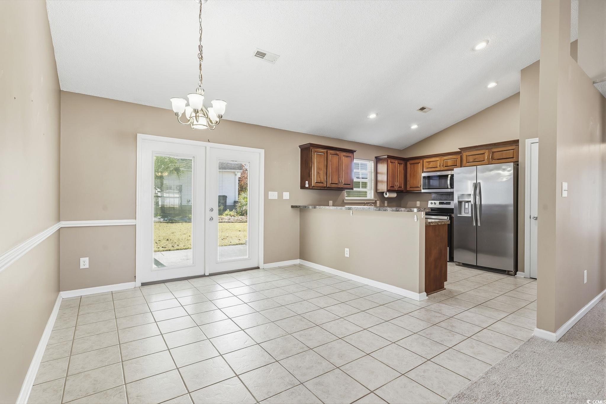 1007 Green Fir Loop Conway, SC 29527 - Photo 9 of 38 Kitchen featuring light tile patterned flooring, stainless steel appliances, decorative light fixtures, a peninsula, and lofted ceiling