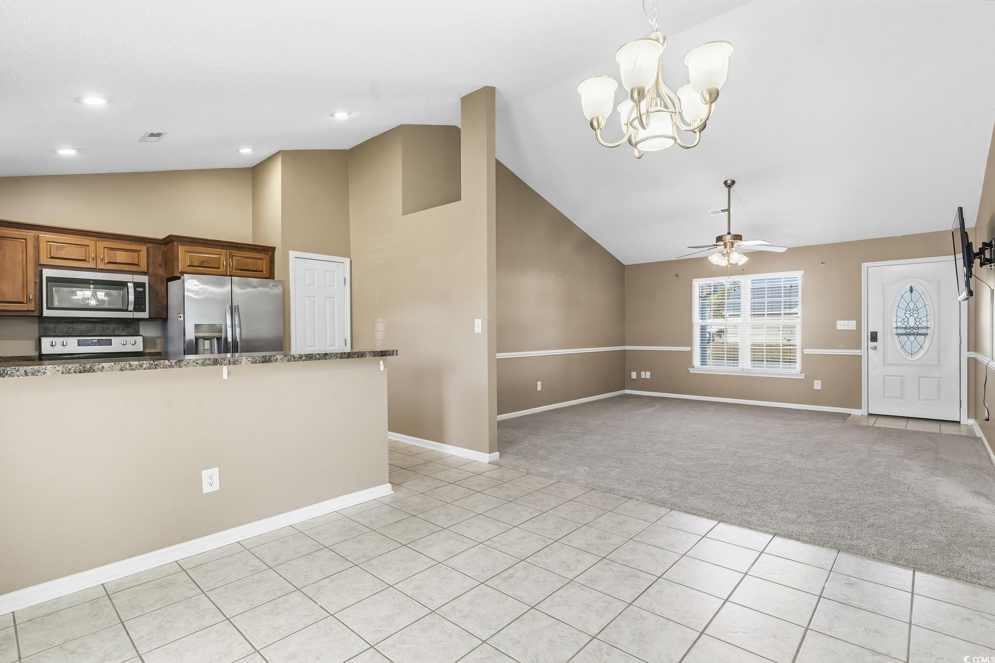 1007 Green Fir Loop Conway, SC 29527 - Photo 10 of 38 Kitchen featuring dark stone counters, light tile patterned floors, high vaulted ceiling, hanging light fixtures, and appliances with stainless steel finishes