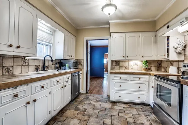 a kitchen with stainless steel appliances granite countertop white cabinets a sink and dishwasher with wooden floor