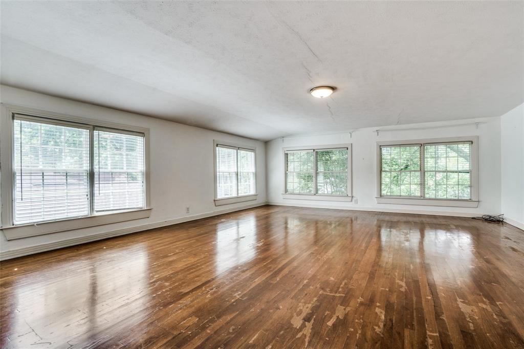 5910 McCommas Boulevard Dallas, TX 75206 - Photo 18 of 22 an empty room with wooden floor and windows