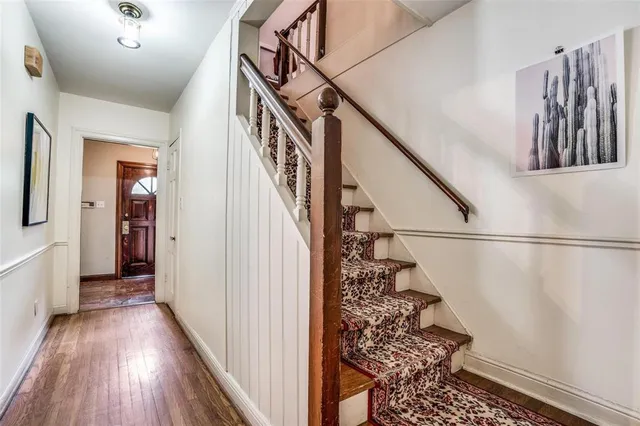 a view of a hallway with wooden floor and stairs