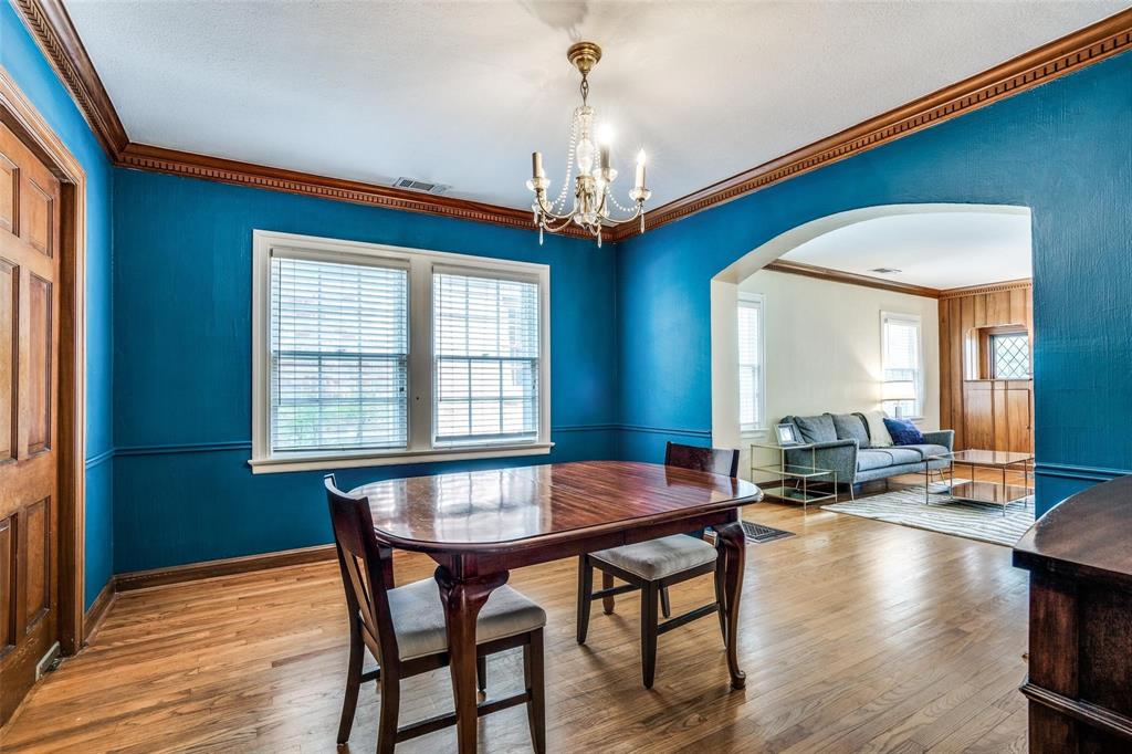 5910 McCommas Boulevard Dallas, TX 75206 - Photo 8 of 22 a dining room with wooden floor a chandelier a wooden table and chairs
