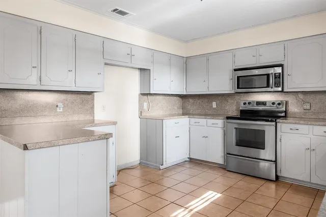 a kitchen with granite countertop white cabinets and sink