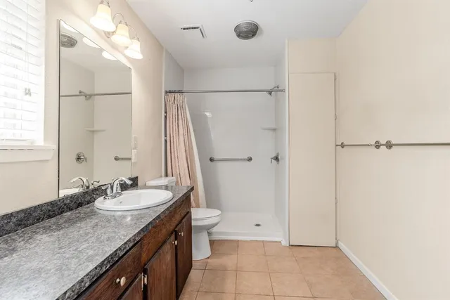 a bathroom with a granite countertop sink and a mirror