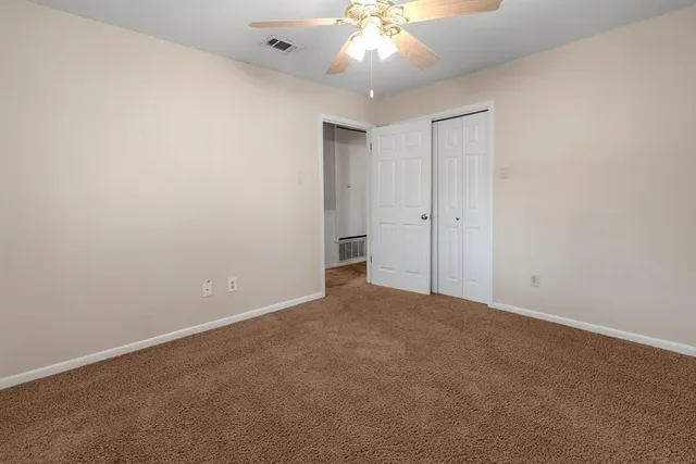 an empty room with a window and a ceiling fan
