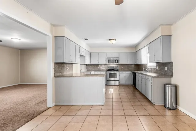 a large kitchen with cabinets and stainless steel appliances