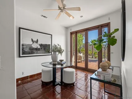 a dining room with furniture potted plants and wooden floor