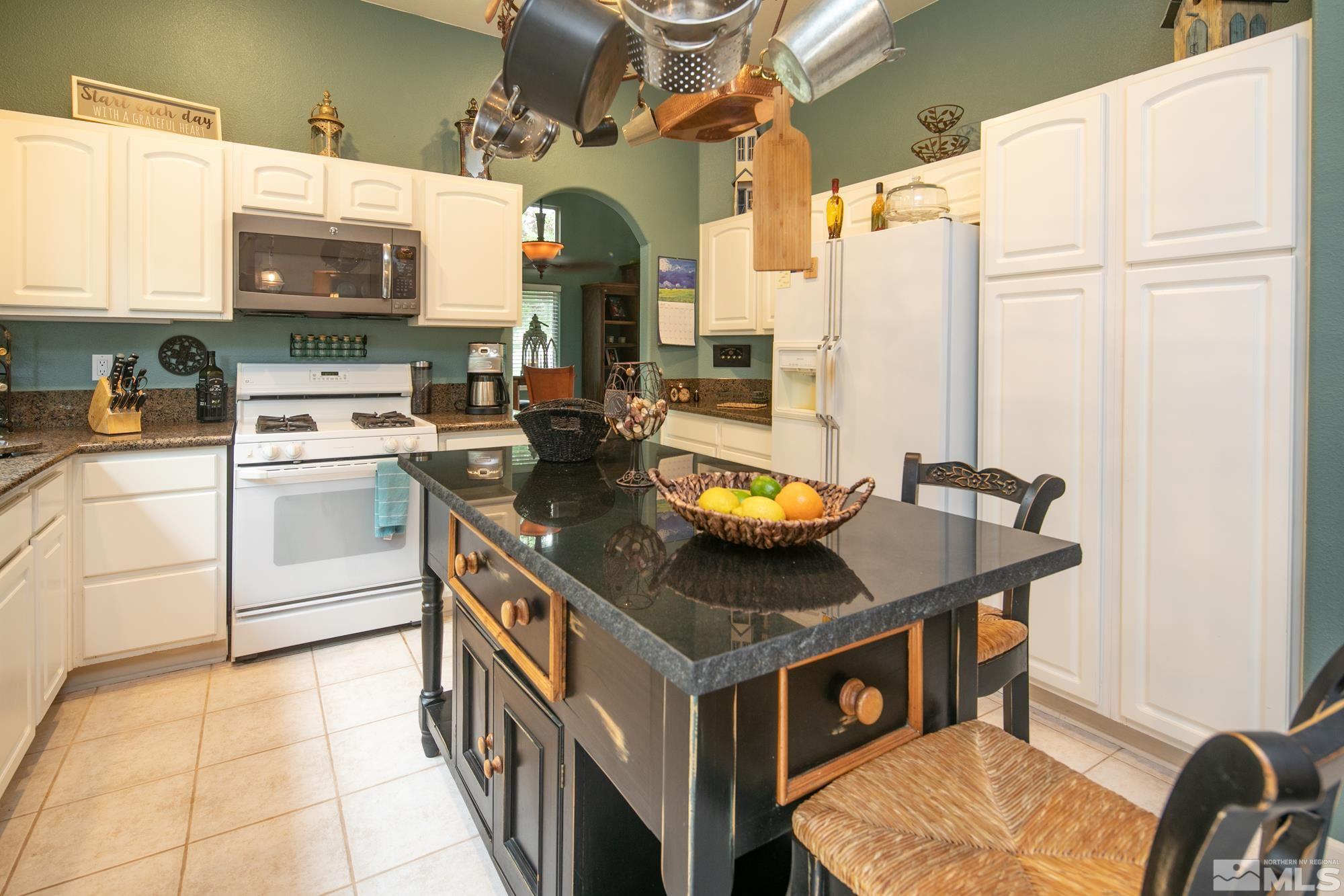 1981 Moon Shadow Drive Reno, NV 89523 - Photo 5 of 26 a kitchen with stainless steel appliances granite countertop a sink a stove and a microwave