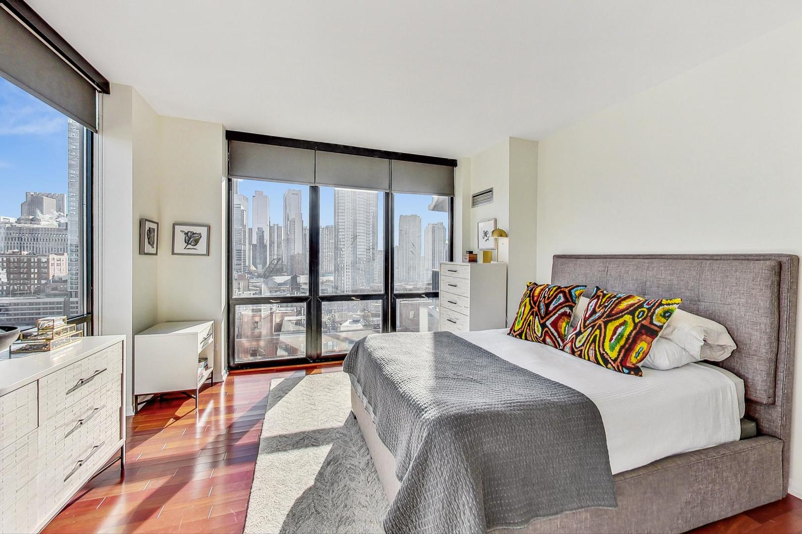 435 West Erie Street, Unit 1501 Chicago, IL 60654 - Photo 12 of 26 a bedroom with a bed couch and large windows