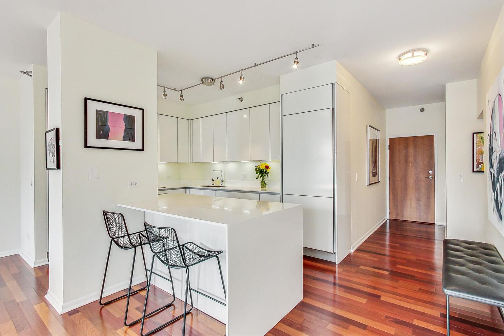 435 West Erie Street, Unit 1501 Chicago, IL 60654 - Photo 9 of 26 a kitchen with stainless steel appliances a refrigerator and wooden floor