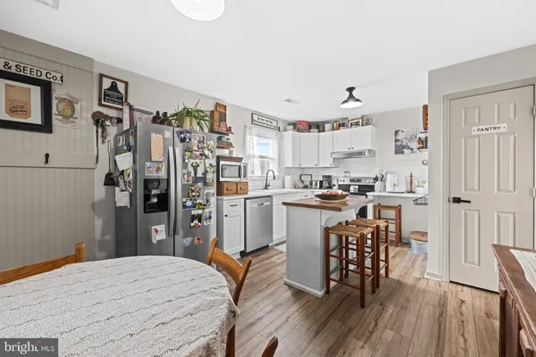 a kitchen with stainless steel appliances kitchen island hardwood floor and refrigerator