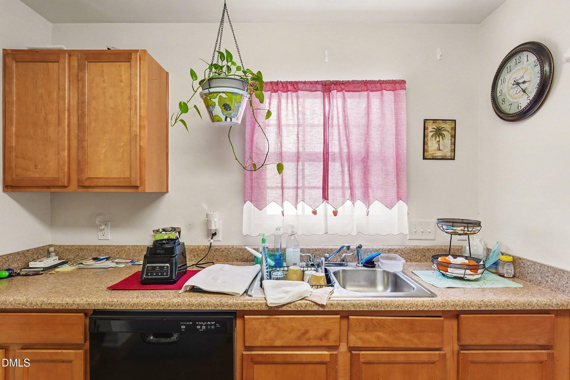1404 Ricochet Drive Raleigh, NC 27610 - Photo 12 of 31 a kitchen with stainless steel appliances granite countertop a sink dishwasher and a stove next to a window