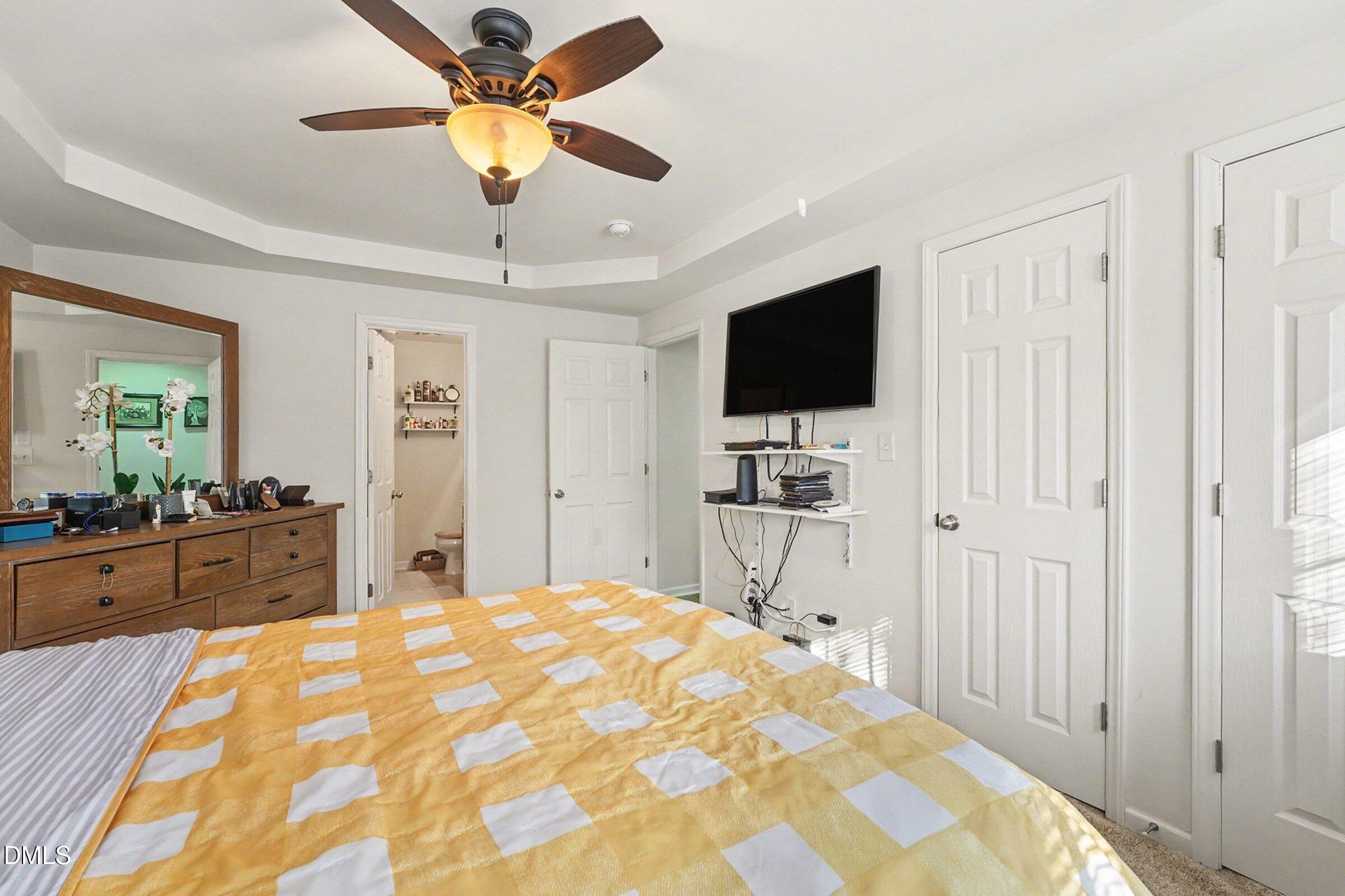 1404 Ricochet Drive Raleigh, NC 27610 - Photo 16 of 31 a bedroom with a bed and a chandelier