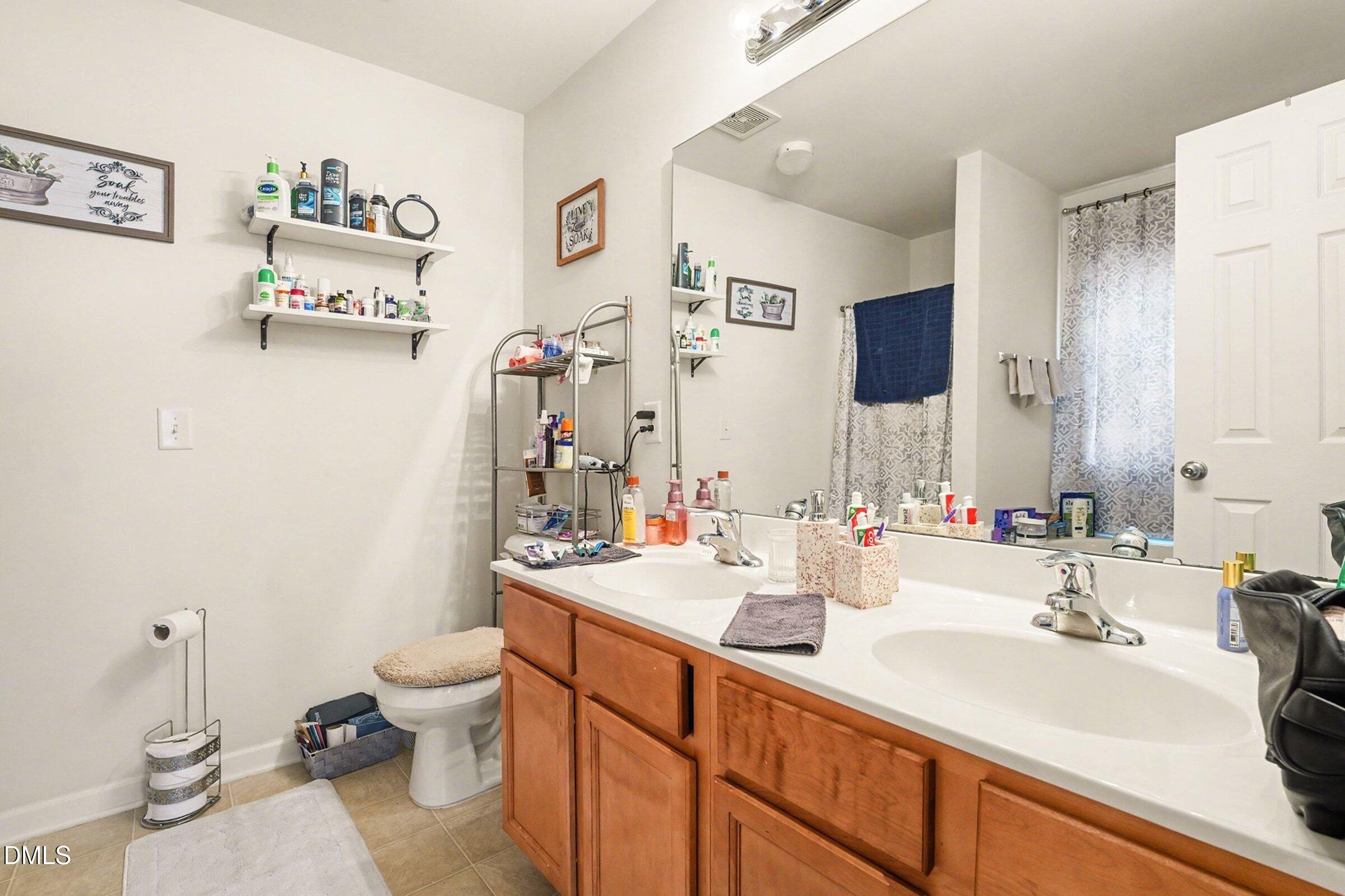 1404 Ricochet Drive Raleigh, NC 27610 - Photo 17 of 31 a bathroom with a sink double vanity and toilet