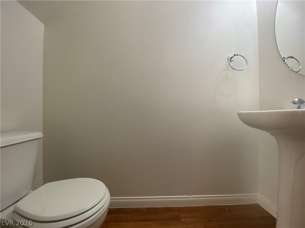 2023 Peacemaker Road Las Vegas, NV 89183 - Photo 20 of 24 A minimalist powder room highlights warm wood flooring and clean, simple wall surfaces.
