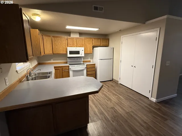 a kitchen with a refrigerator sink and wooden floor