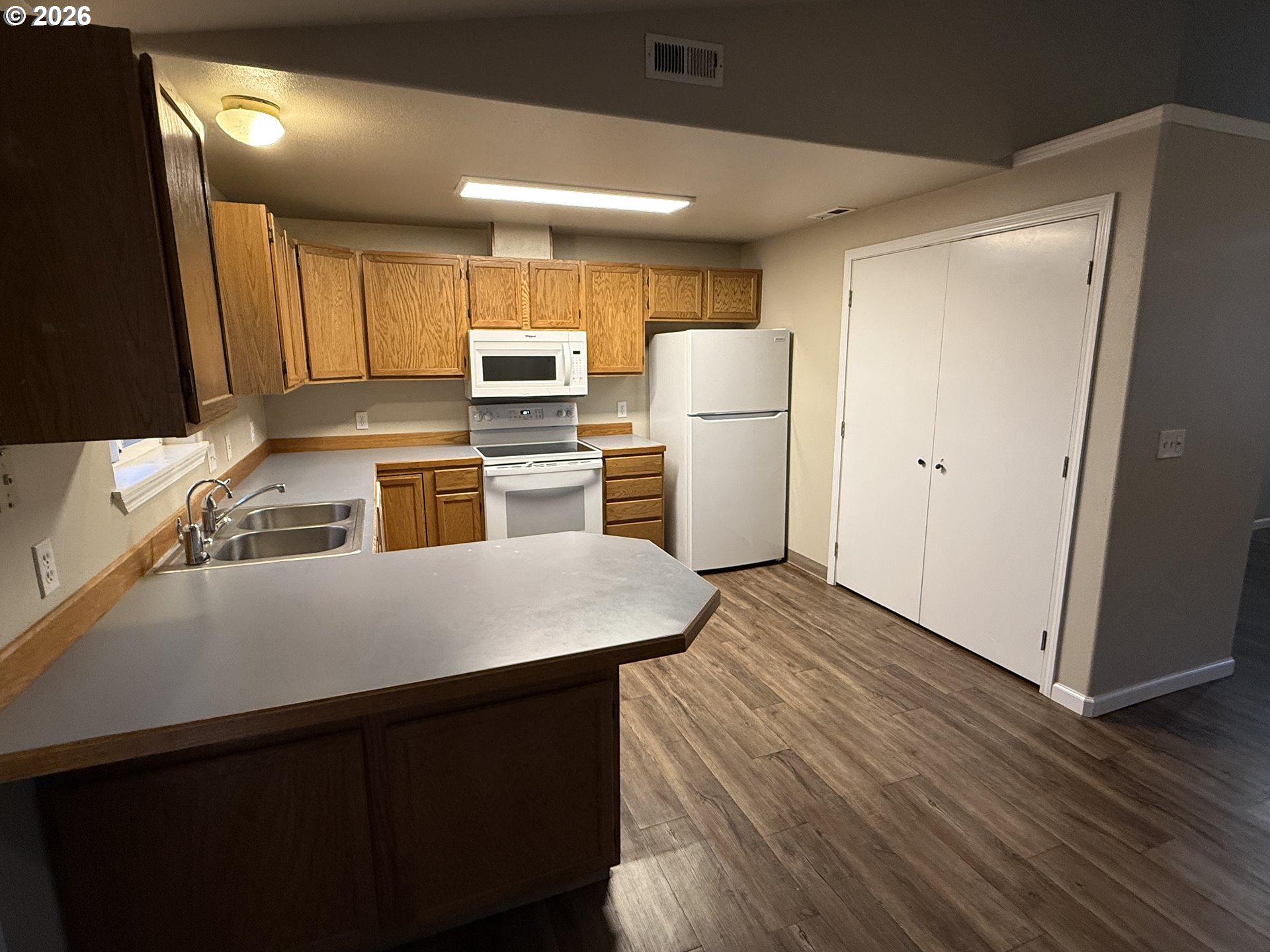 70 Northeast Alora Drive Hermiston, OR 97838 - Photo 5 of 14 a kitchen with a refrigerator sink and wooden floor