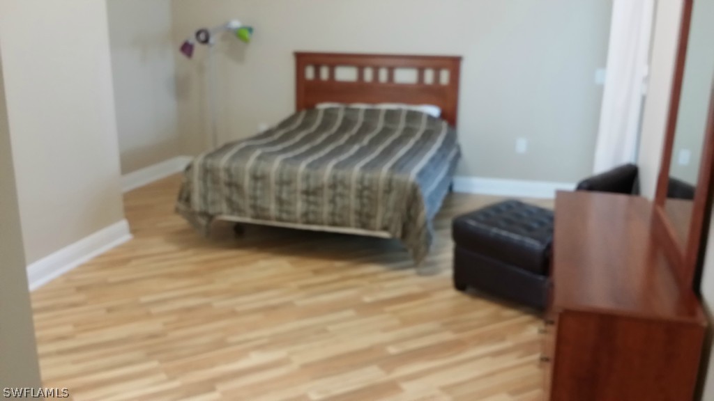 2743 First Street, Unit 305 Fort Myers, FL 33916 - Photo 7 of 21 a bedroom with a bed chair and a wall painting