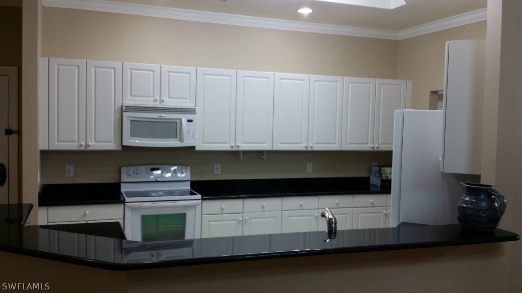 2743 First Street, Unit 305 Fort Myers, FL 33916 - Photo 8 of 21 a kitchen with stainless steel appliances granite countertop white cabinets and a granite counter tops