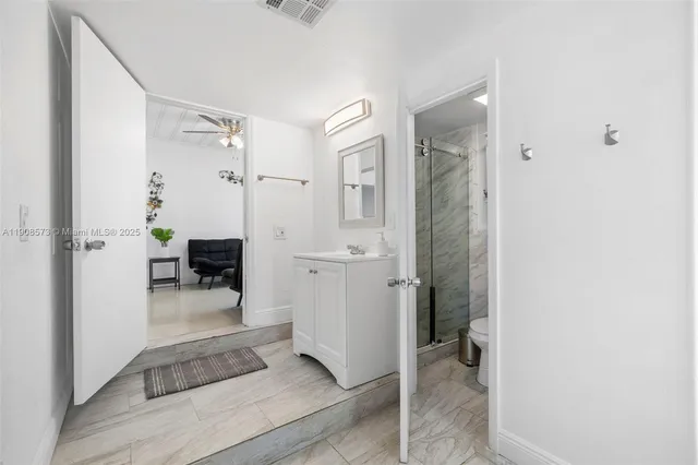 a view of a bathroom with tub shower and mirror