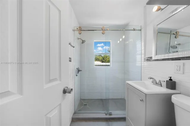 a bathroom with a shower a sink and toilet