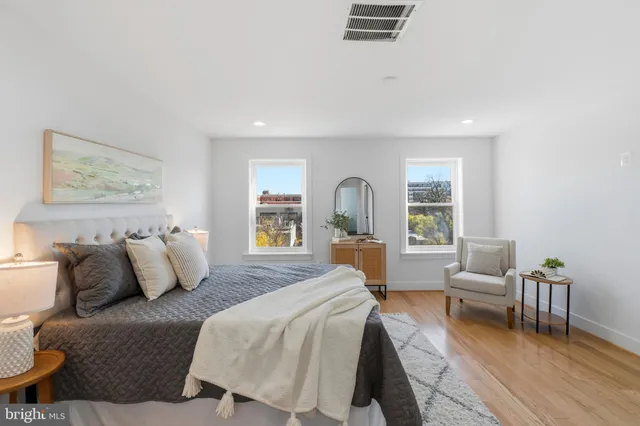 a spacious bedroom with a bed and glass window