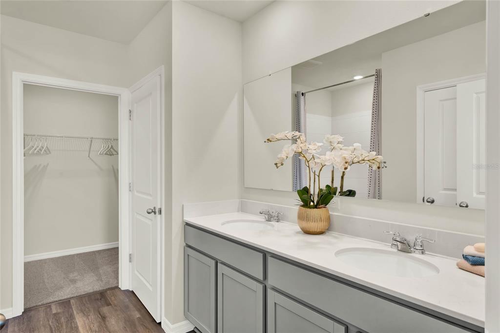 5259 Nickerbean Street Apopka, FL 32712 - Photo 23 of 33 a bathroom with double vanity sinks a mirror and a shower