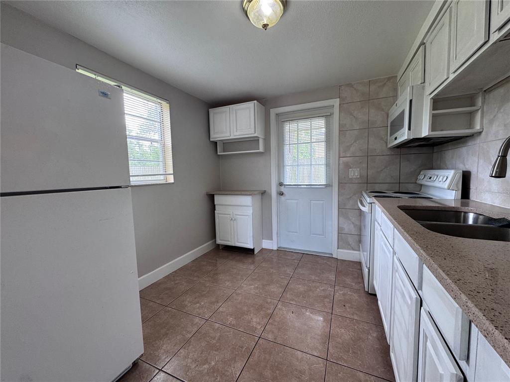 514 Winham Street Tampa, FL 33619 - Photo 5 of 15 a kitchen with stainless steel appliances granite countertop a sink a stove a microwave a sink a refrigerator and cabinets