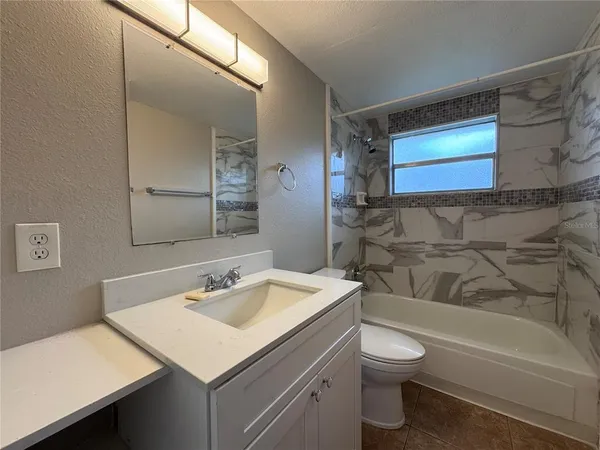 a bathroom with a sink toilet vanity and bathtub