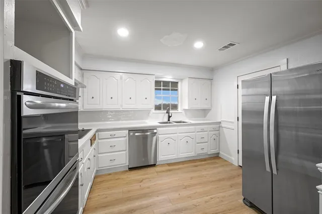 a kitchen with a sink stainless steel appliances and cabinets