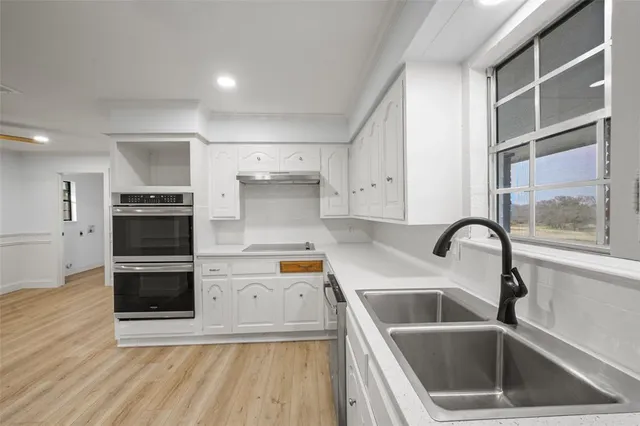 a kitchen with a sink cabinets and stainless steel appliances