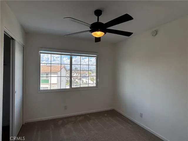 an empty room with windows and fan