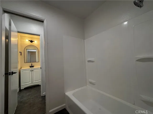 a bathroom with a granite countertop sink and mirror with toilet
